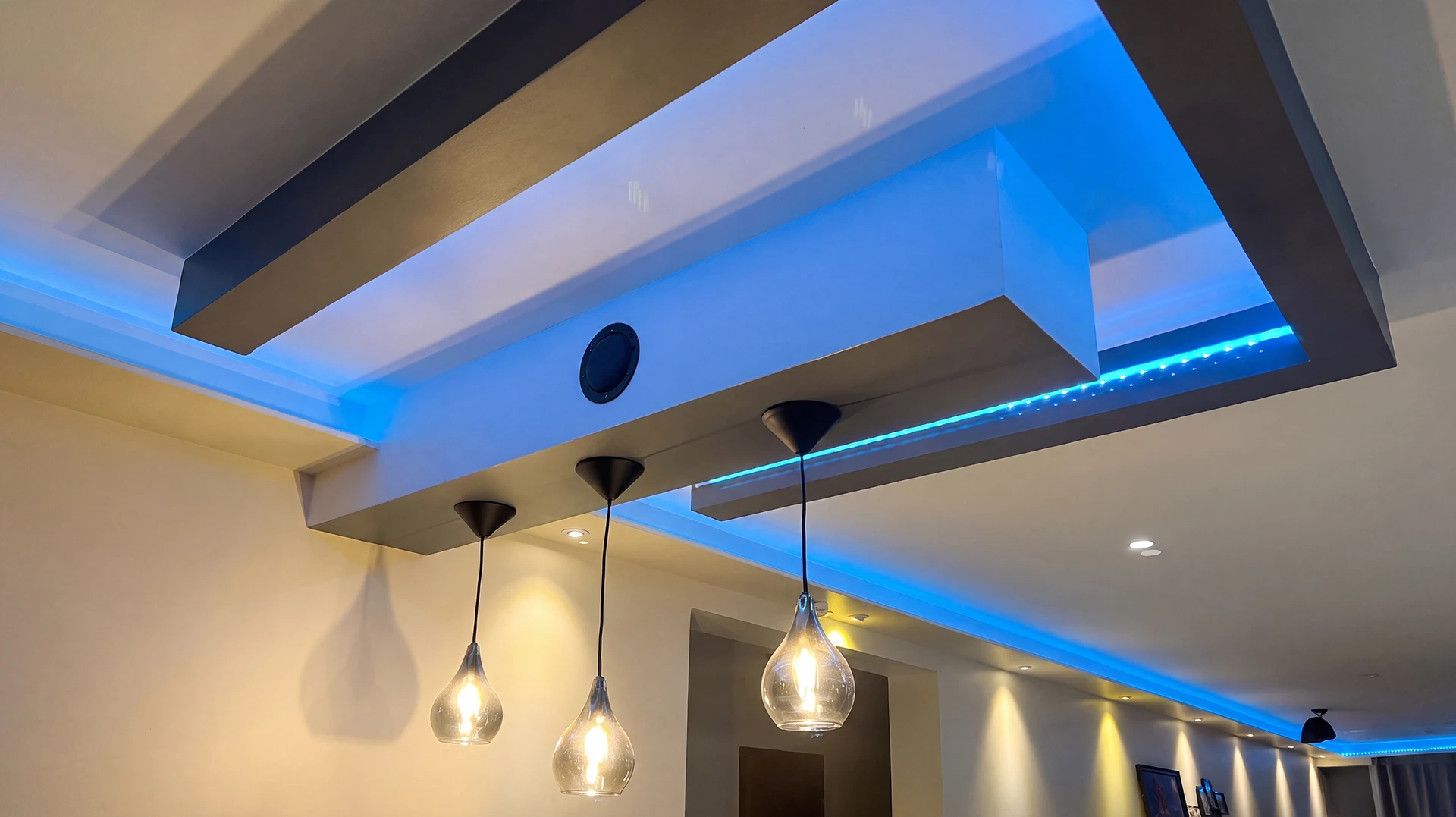 Plafond décoratif intérieur moderne avec caissons en plâtre peint gris anthracite, éclairage indirect LED RGB bleu en corniches dissimulées